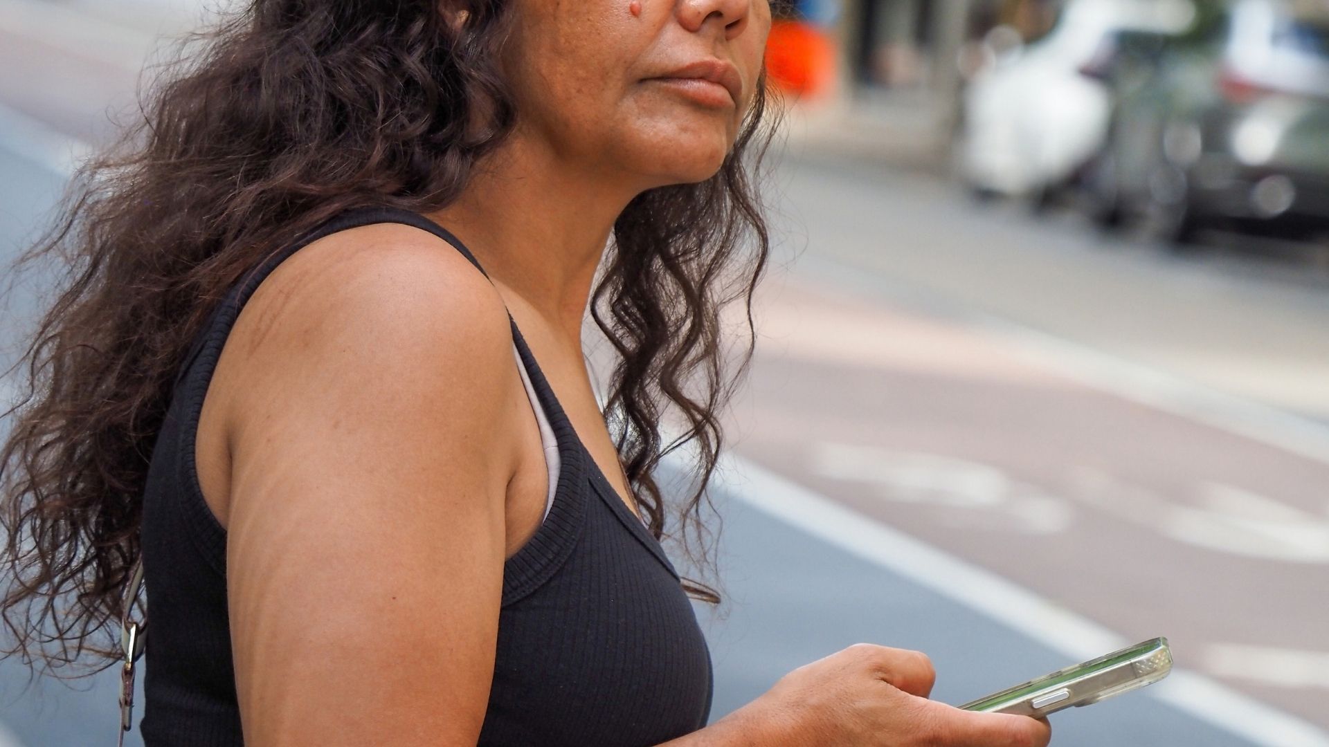 Person holding a mobile phone outdoors.