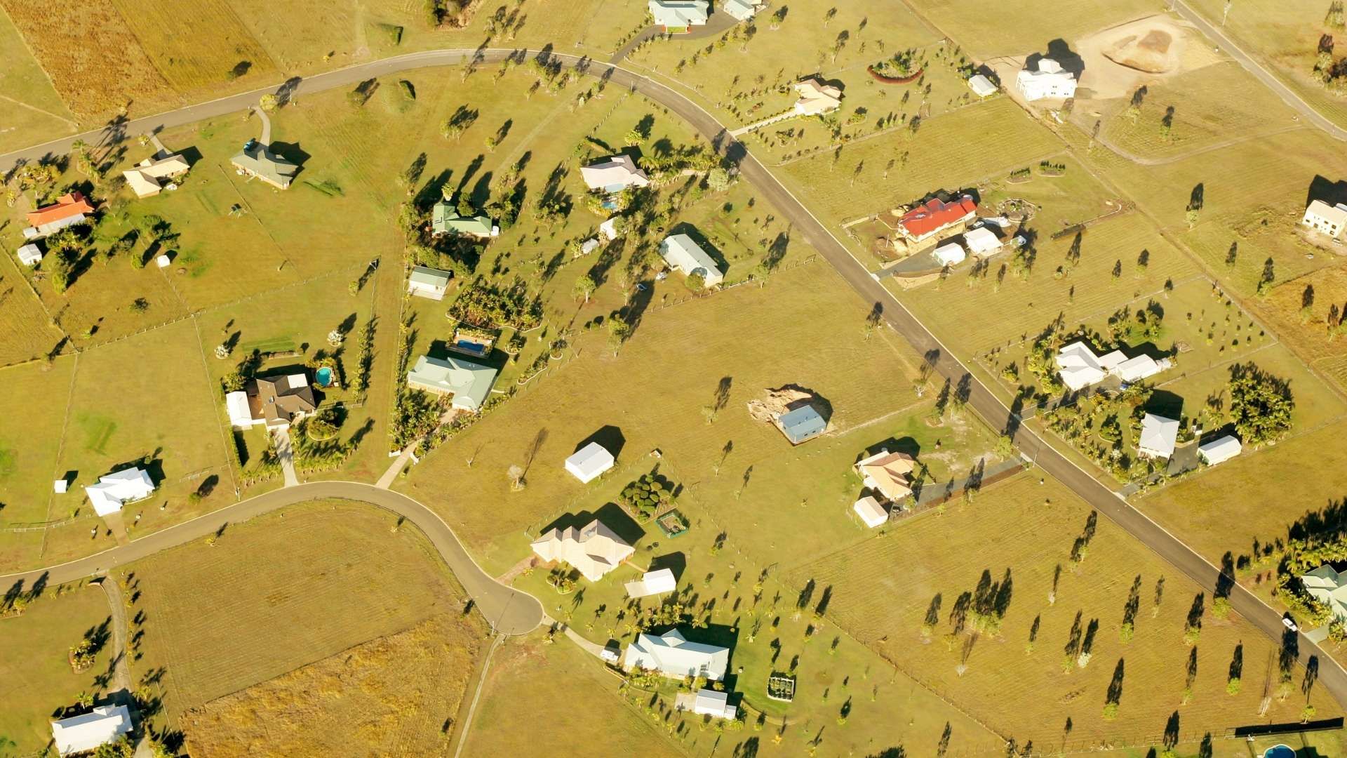 Aerial view of rural properties and roads across open farmland with scattered houses
