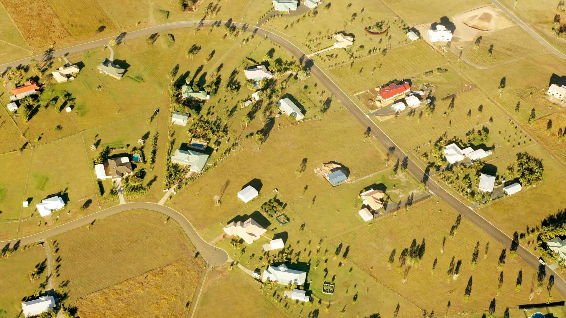 Aerial view of rural properties and roads across open farmland with scattered houses