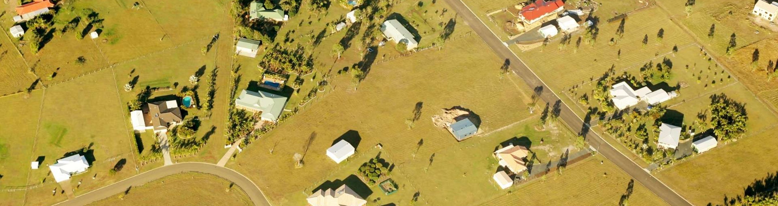 Aerial view of rural properties and roads across open farmland with scattered houses