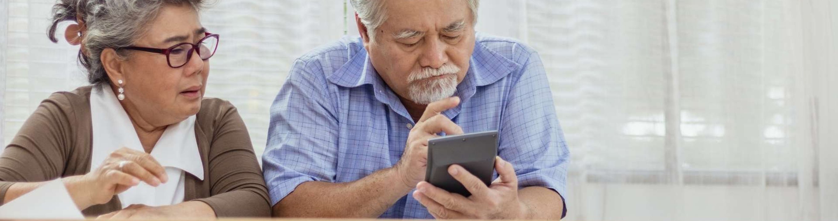 Two people sitting side by side looking at a smartphone together.