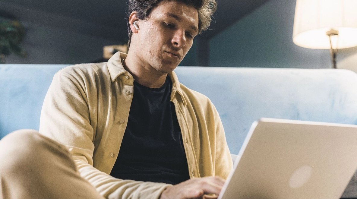 Person sitting in front of a laptop at home.