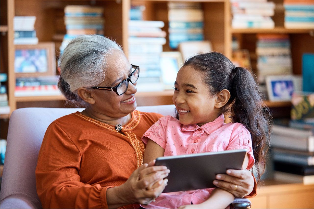 Grandmother and child looking at digital tablet in a lounge room
