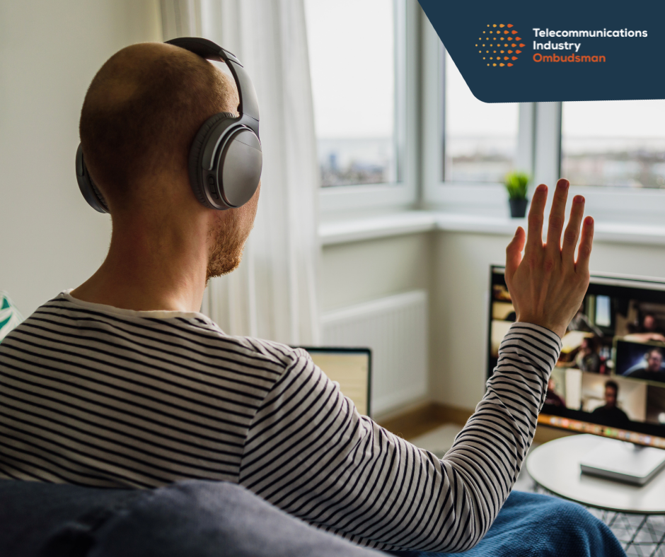 Man waves to computer screen. Screen shows online webinar.