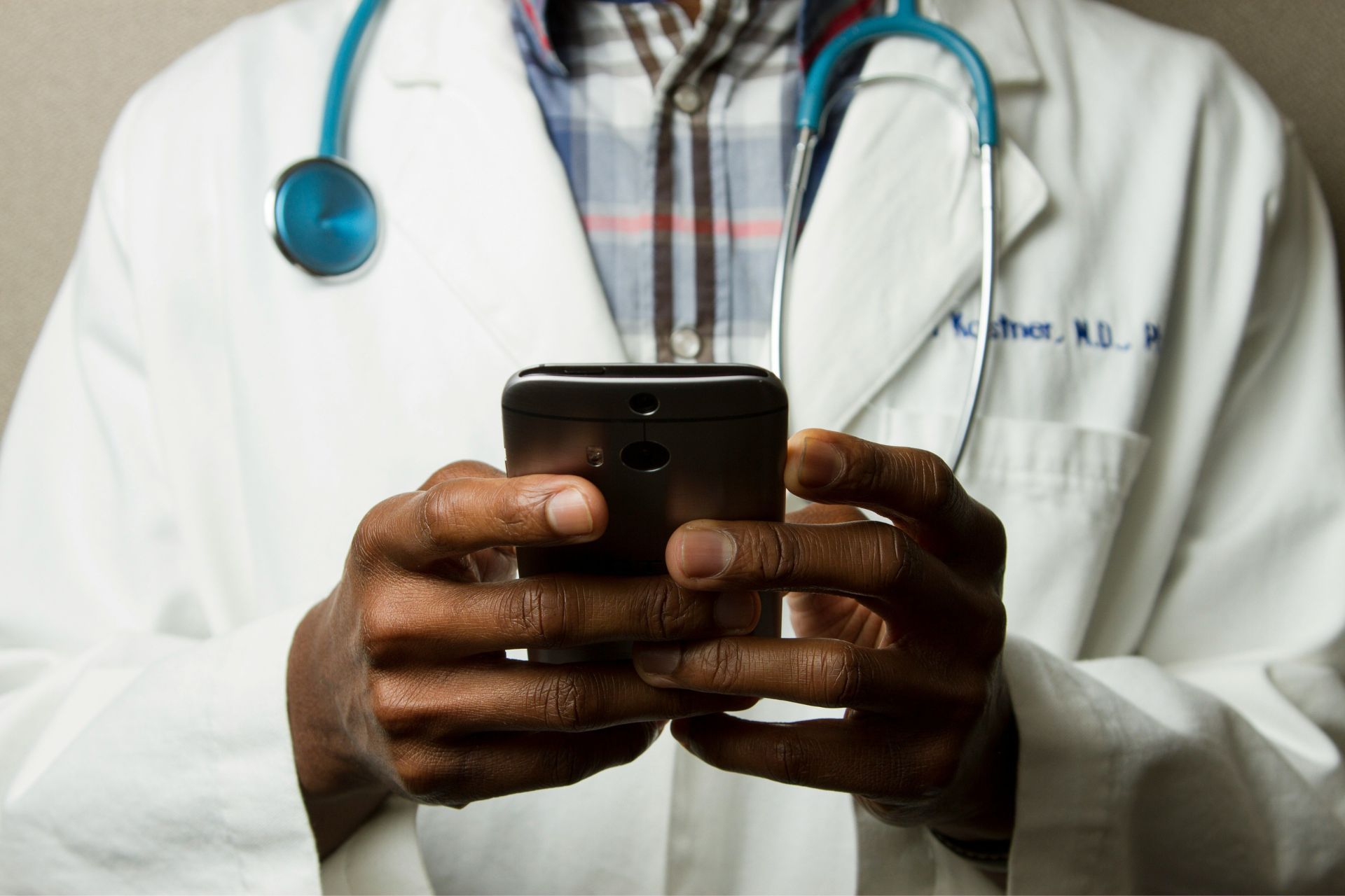 A doctor types on his mobile phone