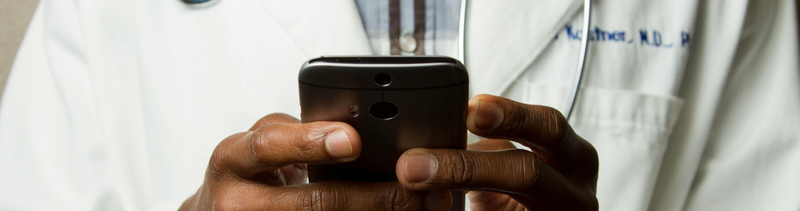 A doctor types on his mobile phone