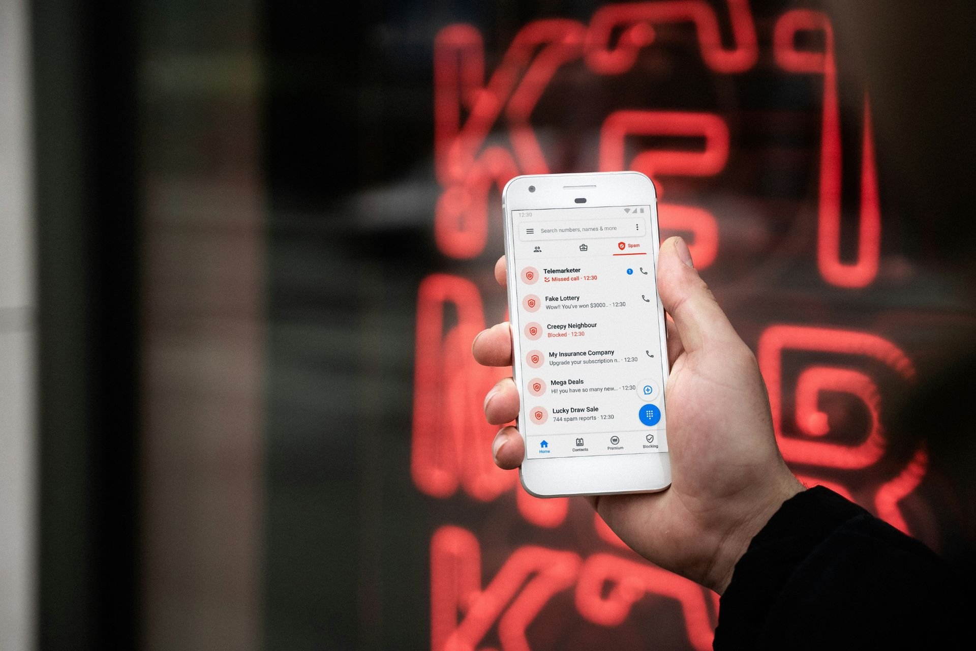 Close-up of a smartphone screen showing a list of blocked and flagged calls.