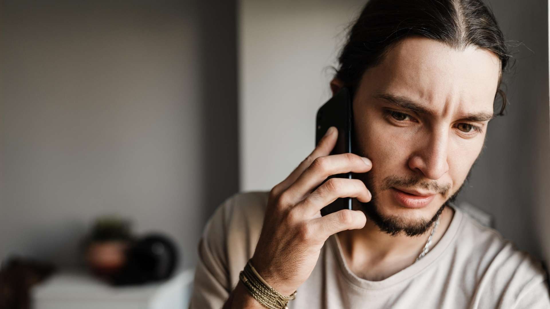 Person holding a mobile phone to ear while looking off-frame