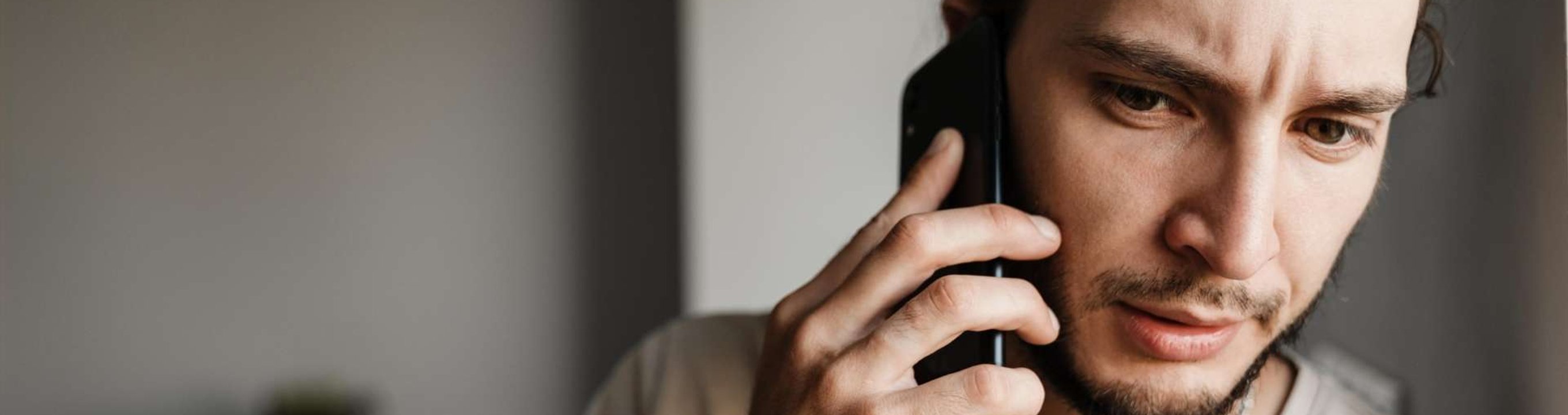 Person holding a mobile phone to ear while looking off-frame