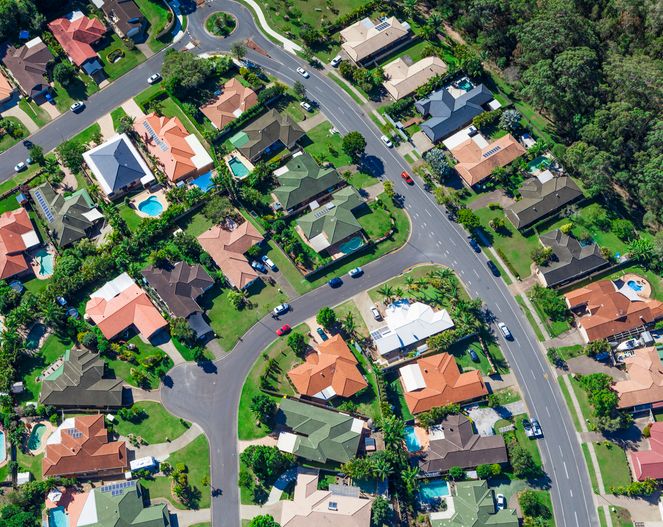 Aerial view of a residential neighbourhood with houses, streets and trees.