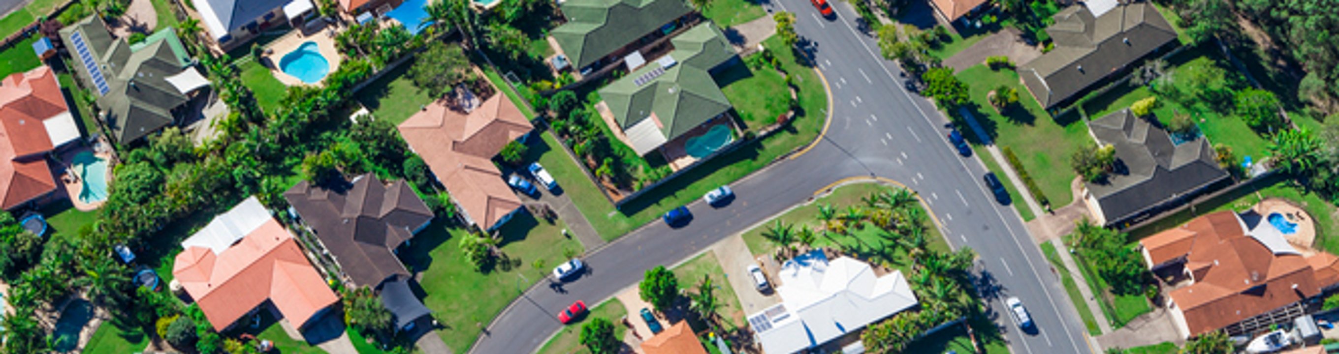 Aerial view of a residential neighbourhood with houses, streets and trees.