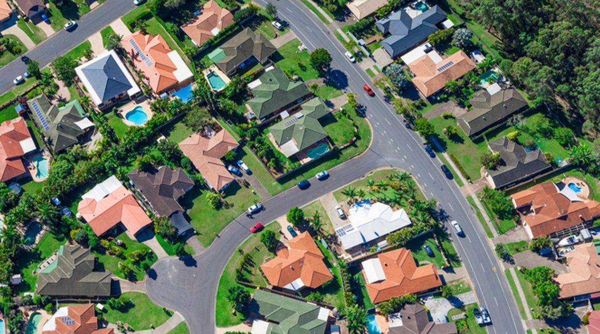 Aerial view of a residential neighbourhood with houses, streets and trees.