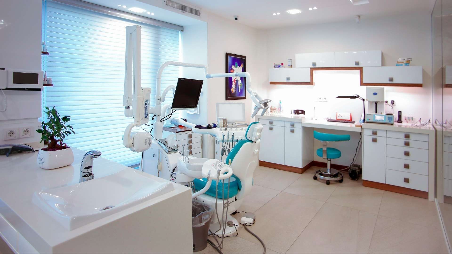 Empty dental clinic room with chair, equipment and workstation.
