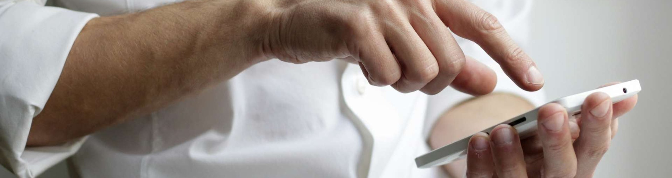 Hand pointing at and using a smartphone.