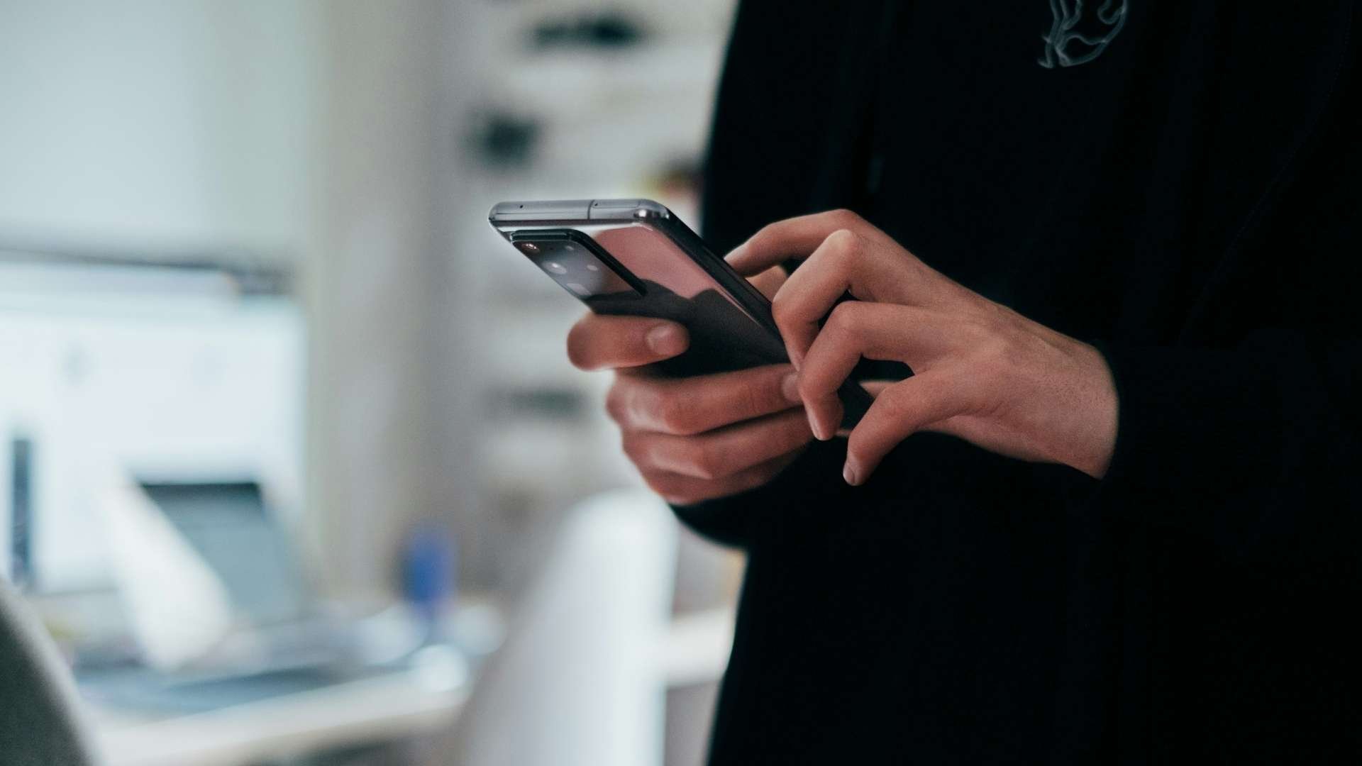Close-up of a person holding and using a smartphone.