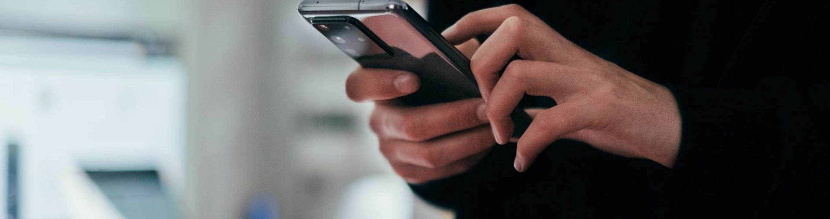 Close-up of a person holding and using a smartphone.