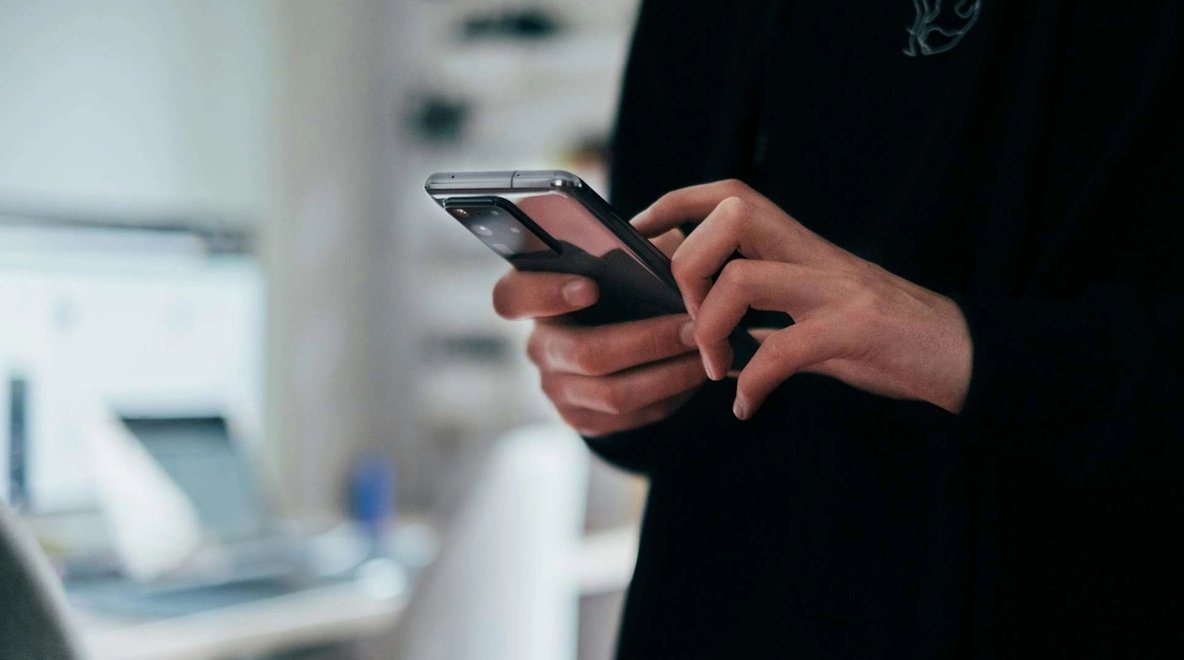 Close-up of a person holding and using a smartphone.