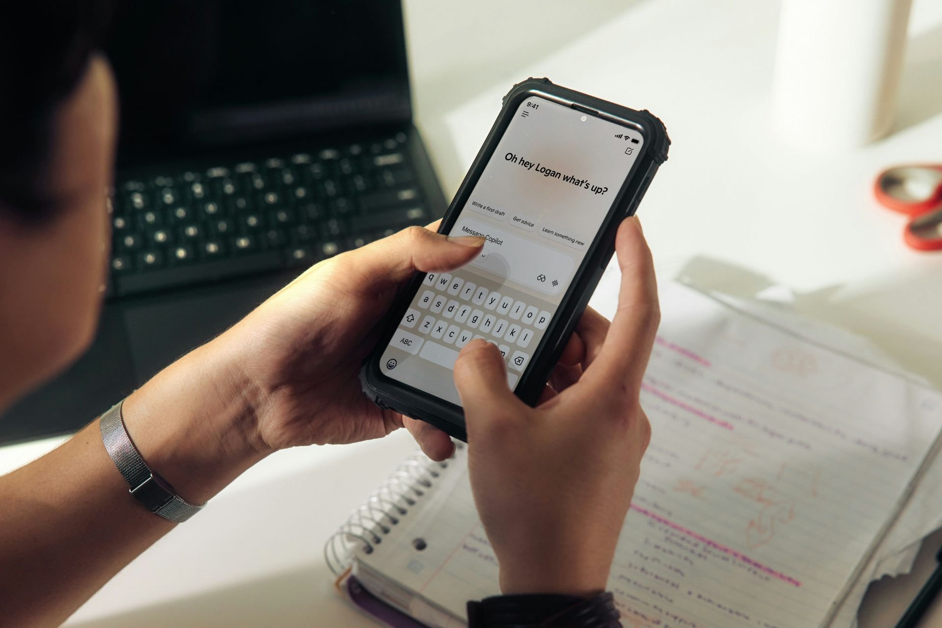 Close-up of a person holding a smartphone and typing a message on the screen.
