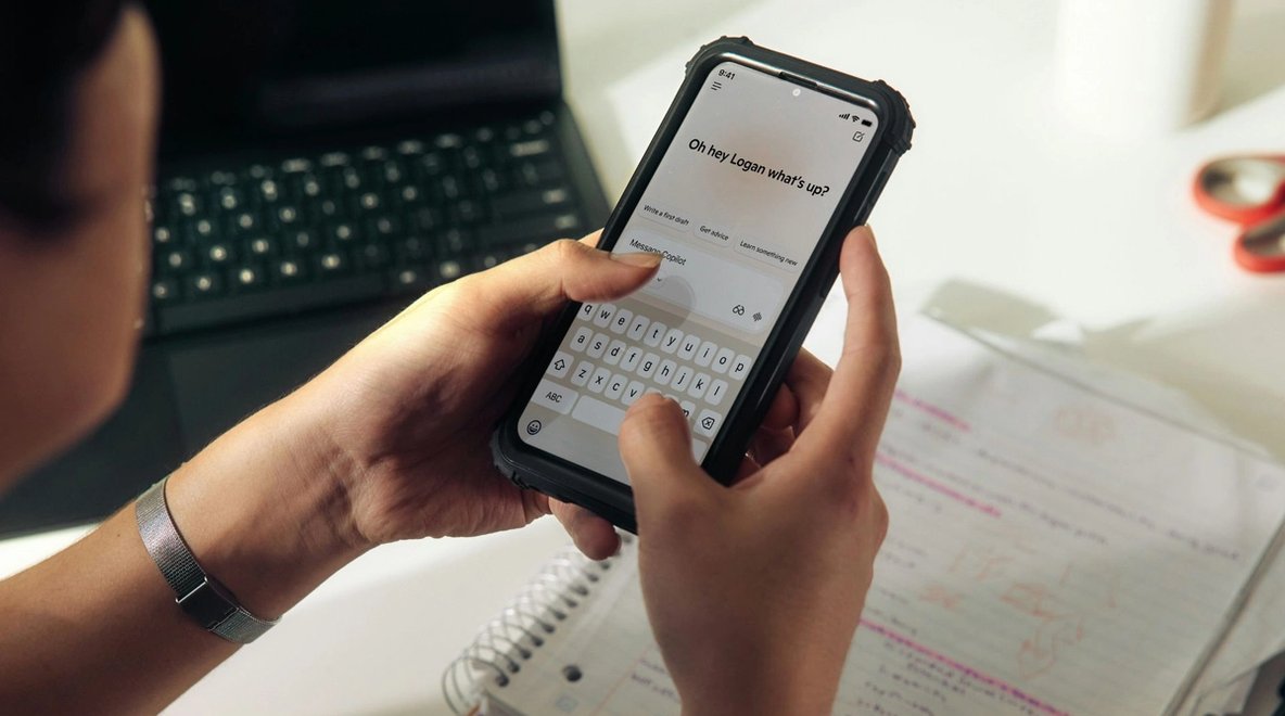 Close-up of a person holding a smartphone and typing a message on the screen.