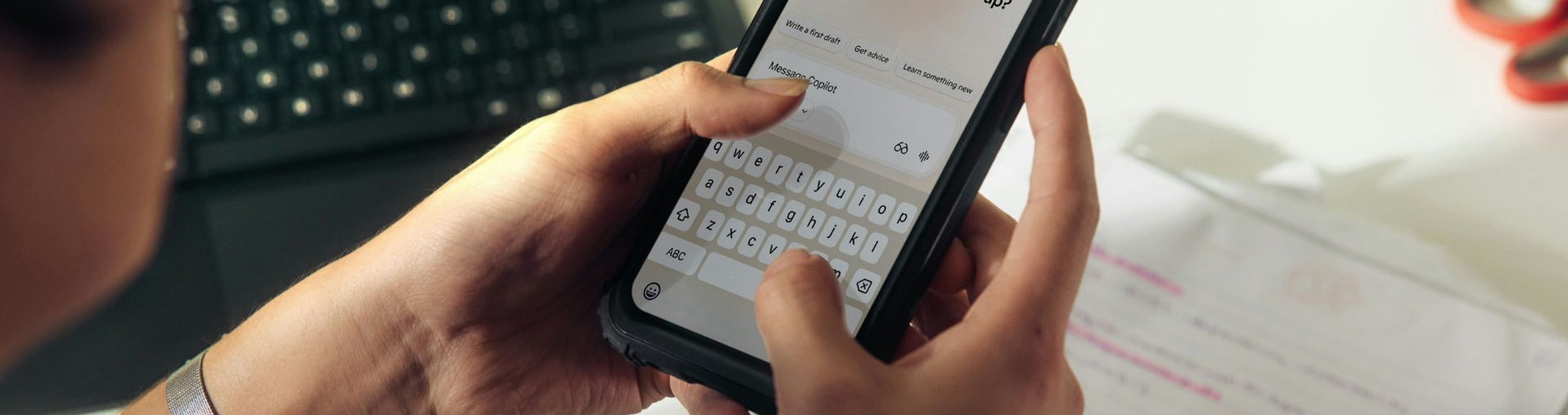 Close-up of a person holding a smartphone and typing a message on the screen.
