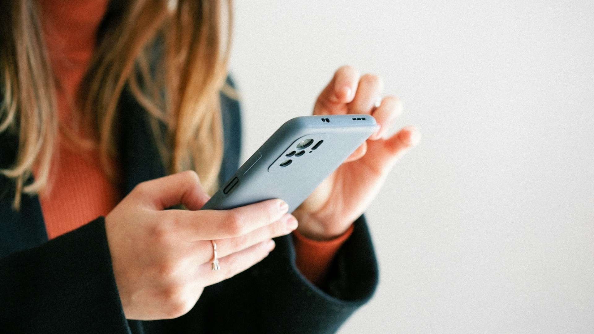 Person holding a smartphone and tapping on the screen