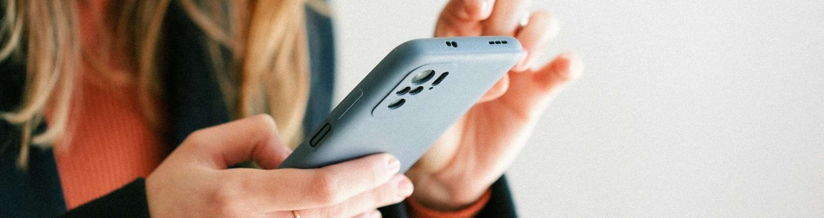 Person holding a smartphone and tapping on the screen