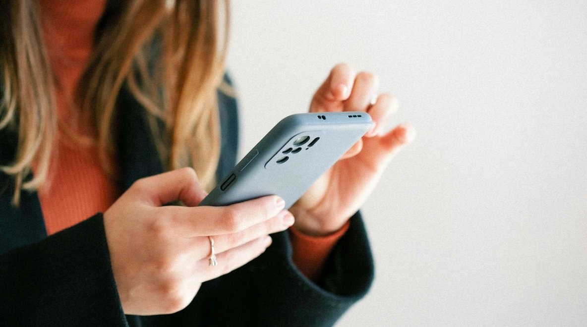 Person holding a smartphone and tapping on the screen
