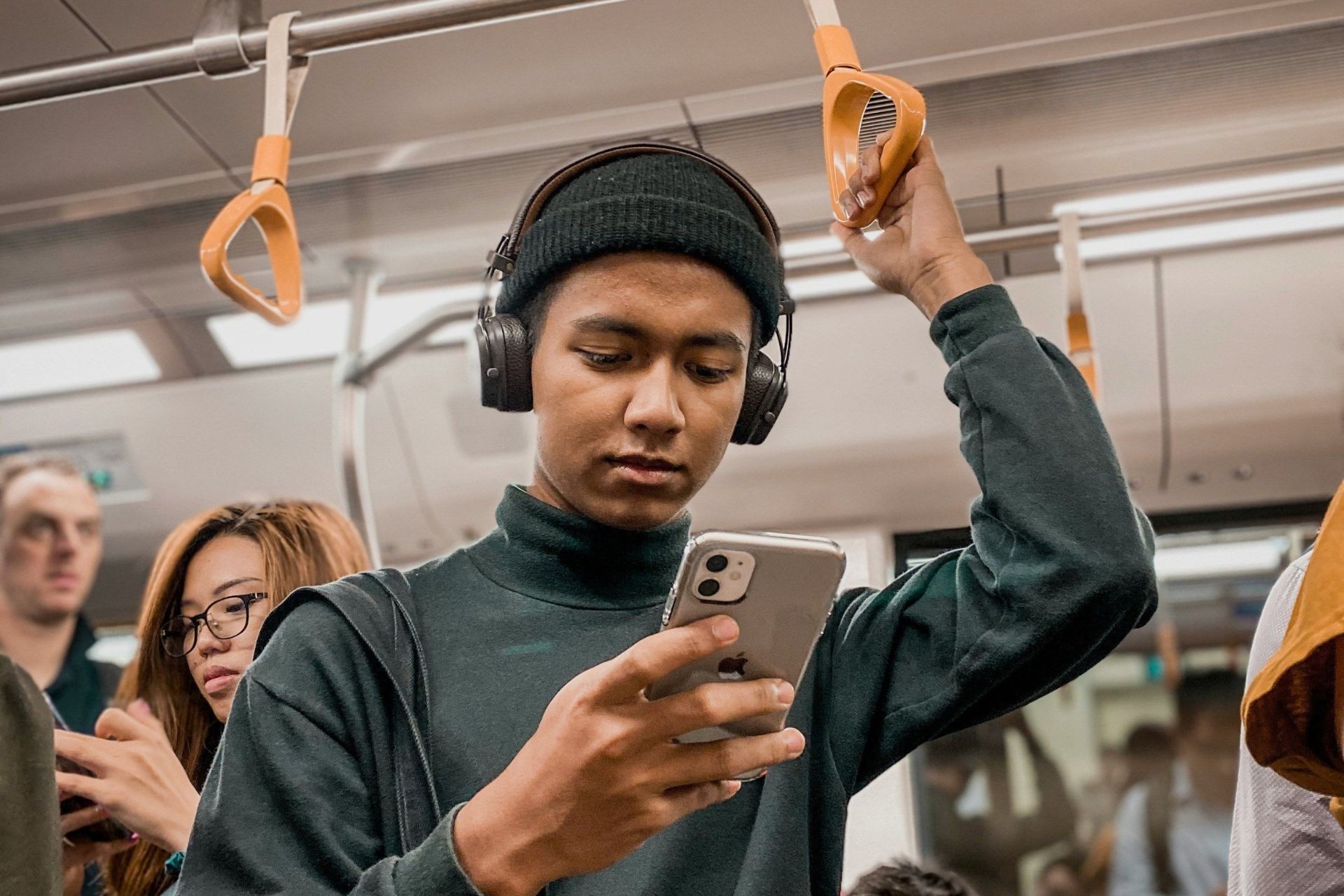 Person standing in public transport and using a smartphone.
