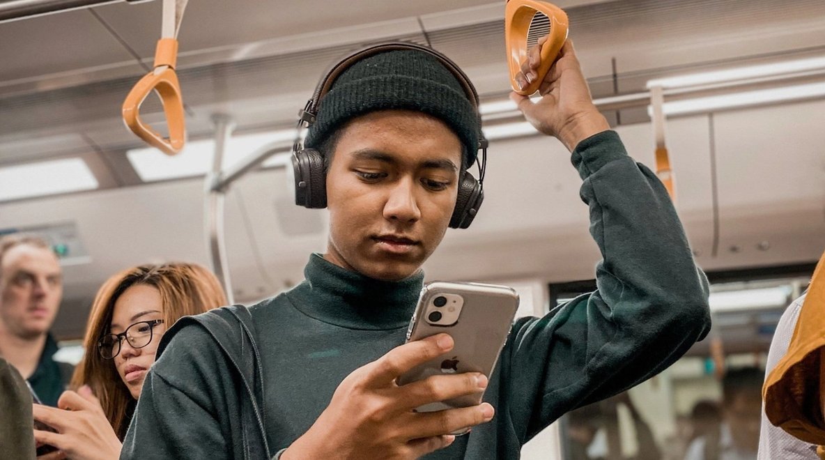Person standing in public transport and using a smartphone.